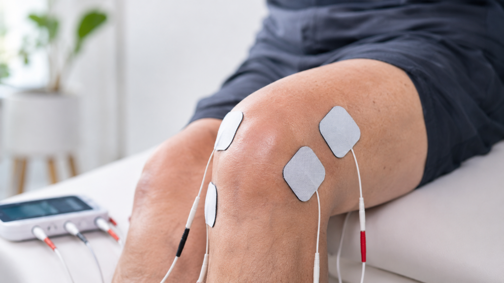Placement d’électrodes autour du genou pour accompagner le soulagement d’une tendinite à l’aide d’un électrostimulateur.